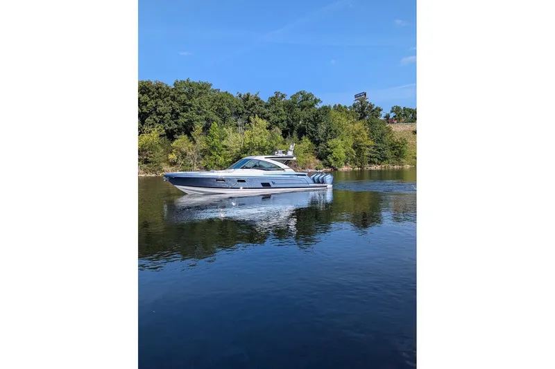 Slide: The Image of 2024 Formula 430 Super Sport Crossover boat cruising on a serene lake. - 16