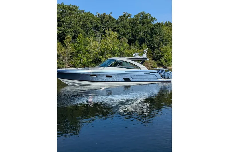 Slide: The Image of 2024 Formula 430 Super Sport Crossover yacht on calm water, surrounded by lush greenery. - 17