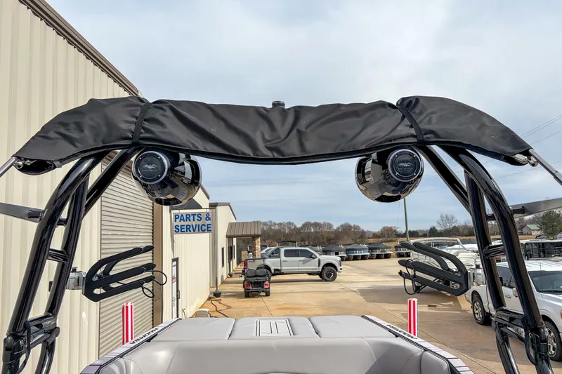 Slide: The Image of 2024 Moomba Max boat with speakers and wakeboard racks at service center. - 12