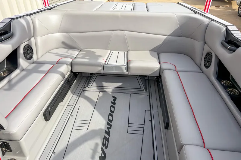 Slide: The Image of 2024 Moomba Max boat interior with gray seating and red accents. - 7