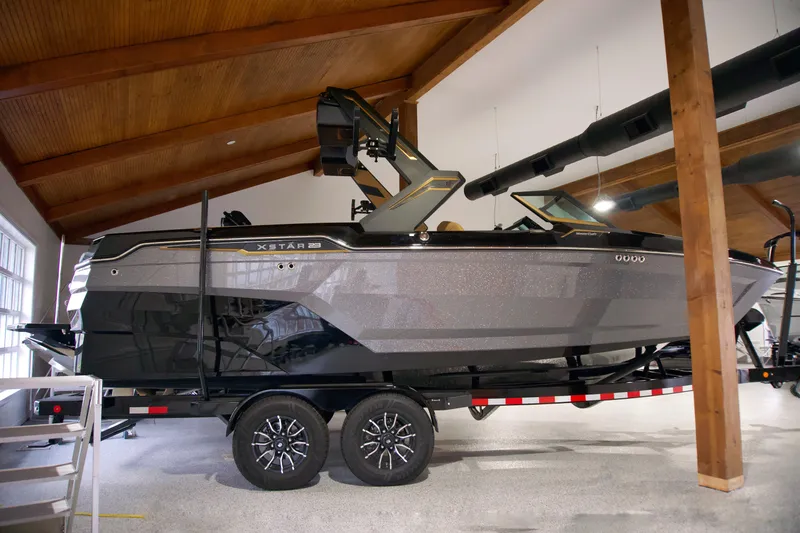 Slide: The Image of 2025 MasterCraft XStar 23 boat on trailer in indoor showroom. - 16