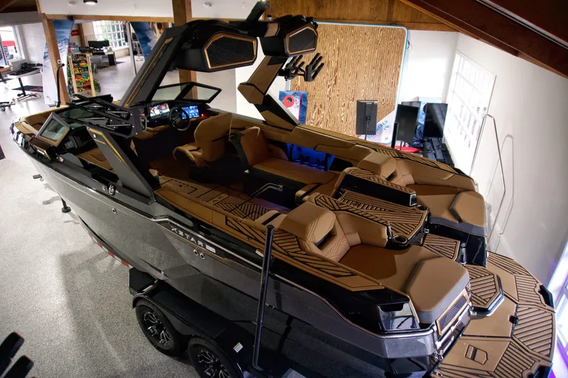 Slide: The Image of 2025 MasterCraft XStar 23 boat with luxurious interior and advanced dashboard in showroom. - 3