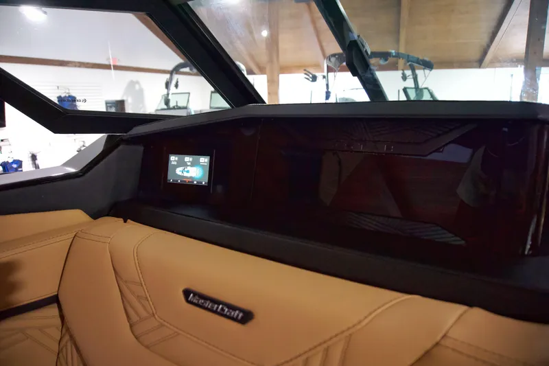 Slide: The Image of 2025 MasterCraft XStar 23 interior dashboard with touchscreen display and tan leather seating. - 9