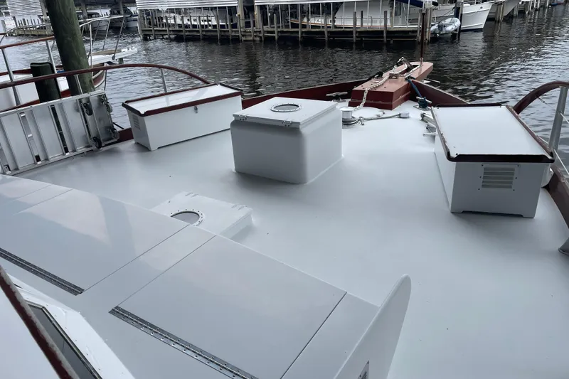 Slide: The Image of 1967 Huckins Offshore boat deck with storage boxes, docked at a marina. - 10