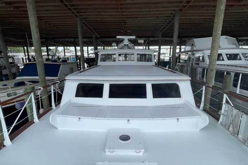 Slide: The Image of 1967 Huckins Offshore yacht docked in a covered marina, showcasing classic design. - 11