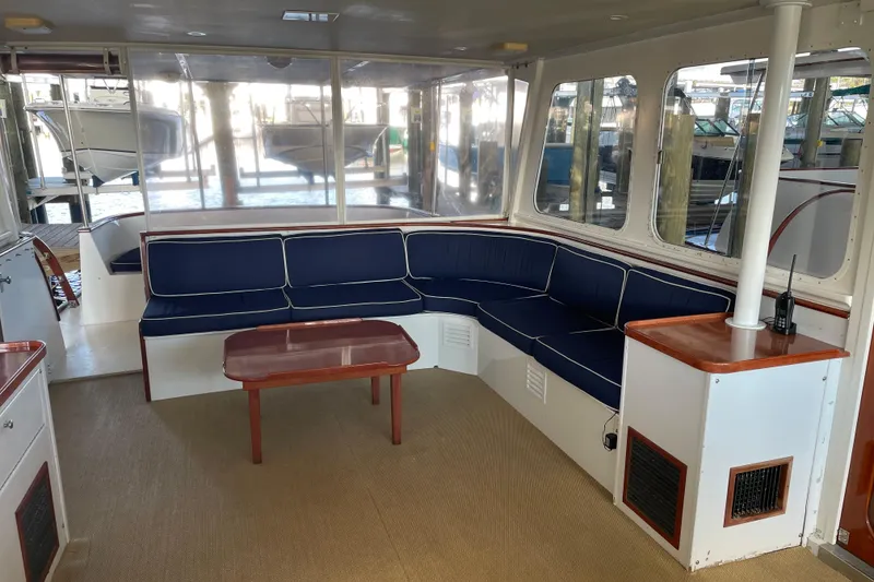 Slide: The Image of 1967 Huckins Offshore yacht interior with blue seating and wooden table. - 16