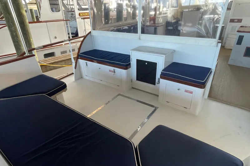 Slide: The Image of 1967 Huckins Offshore yacht interior with blue cushioned seating and white cabinetry. - 19