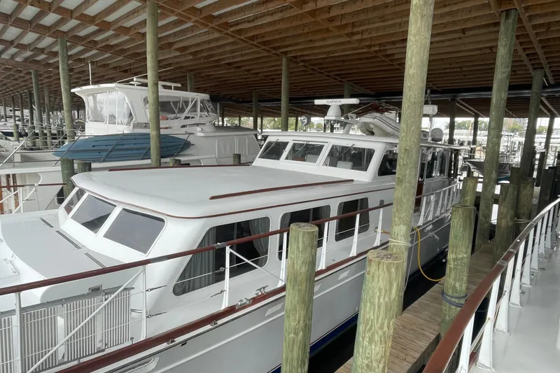 Slide: The Image of 1967 Huckins Offshore yacht docked in a covered marina, showcasing classic design. - 2