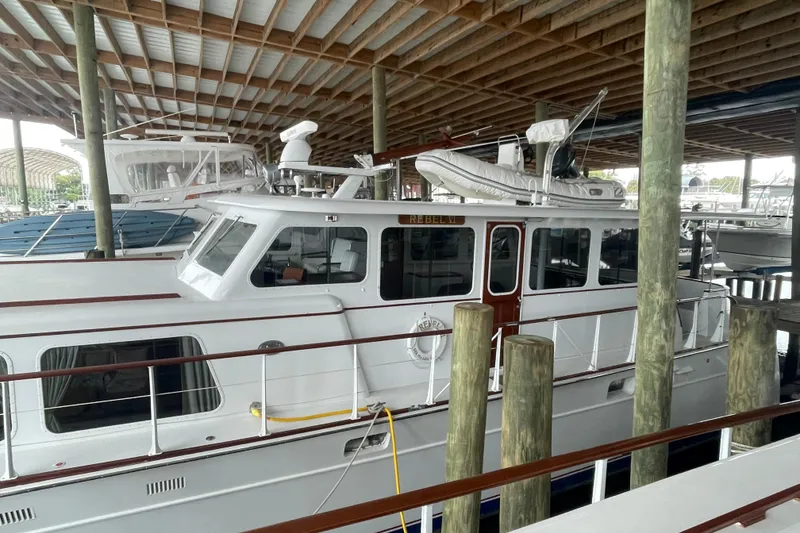 Slide: The Image of 1967 Huckins Offshore yacht docked in a covered marina, showcasing classic design. - 3