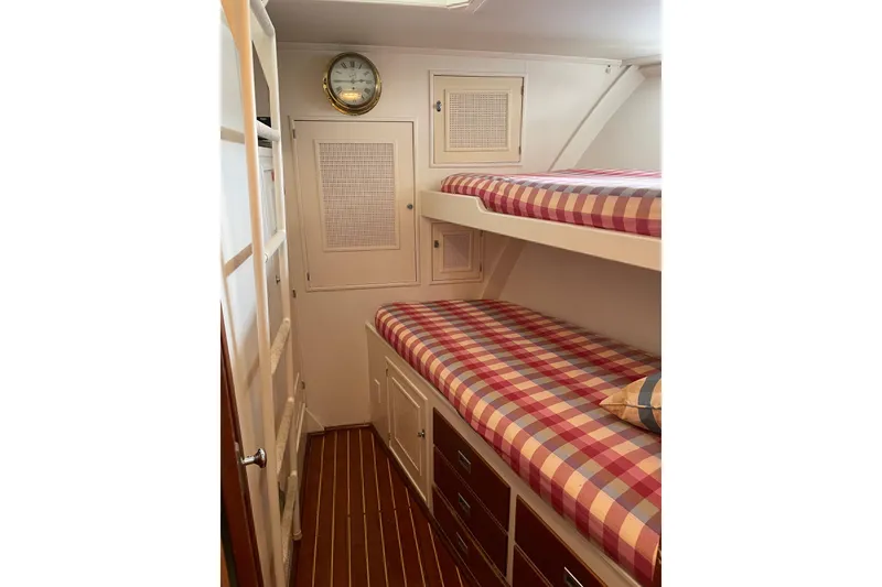 Slide: The Image of 1967 Huckins Offshore cabin with plaid bunk beds and nautical decor. - 30