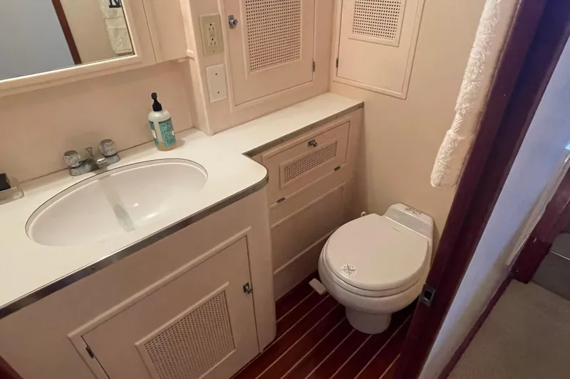 Slide: The Image of 1967 Huckins Offshore yacht bathroom with sink, toilet, and wooden flooring. - 33