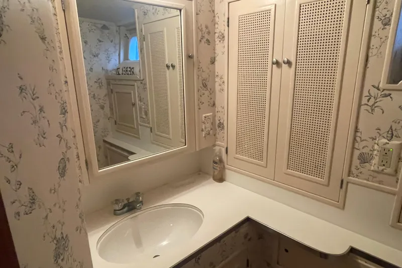 Slide: The Image of Vintage 1967 Huckins Offshore yacht bathroom with floral wallpaper and classic cabinetry. - 40