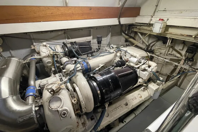 Slide: The Image of Engine room of a 1967 Huckins Offshore boat, showcasing dual engines and mechanical components. - 42