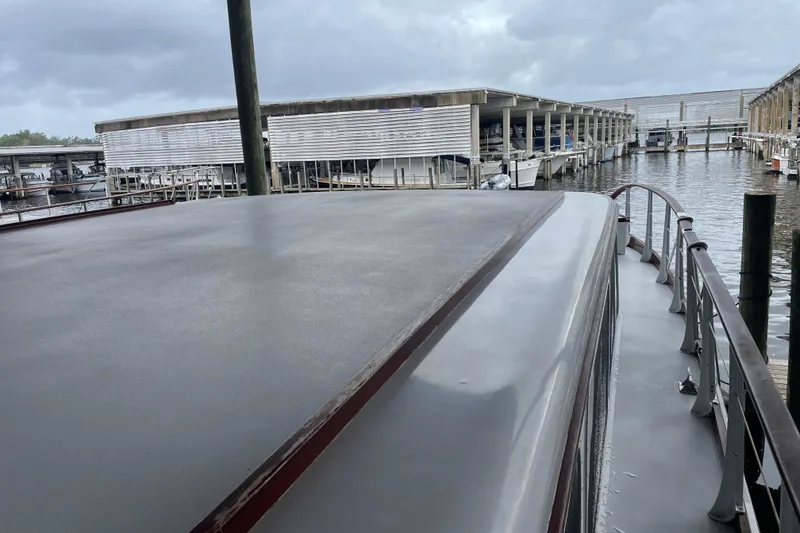 Slide: The Image of 1967 Huckins Offshore boat docked at a marina under cloudy skies. - 9