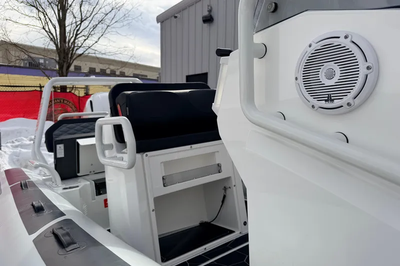 Slide: The Image of 2025 Highfield Sport 560 boat interior with seating and speaker, docked in snowy setting. - 12