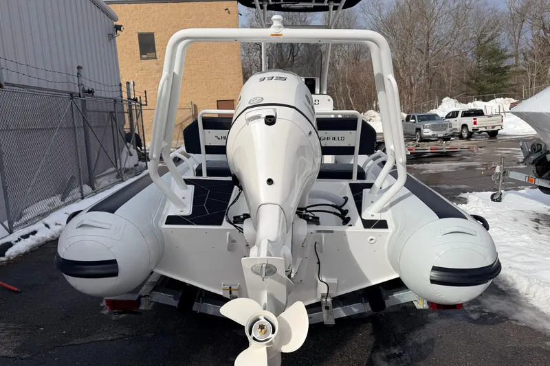 Slide: The Image of 2025 Highfield Sport 560 boat with outboard motor, parked in snowy outdoor setting. - 6