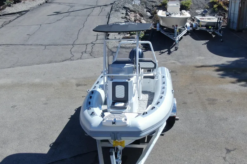 Slide: The Image of 2025 Sport 560 boat on trailer in outdoor storage area. - 2