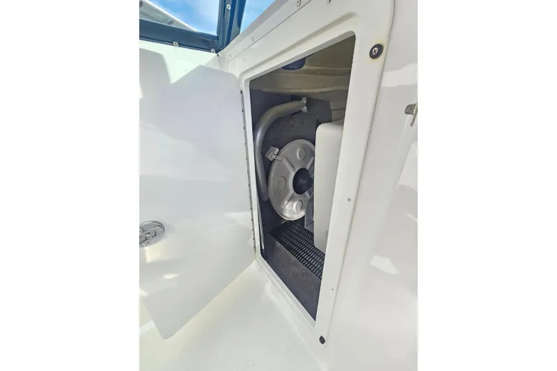 Slide: The Image of Open storage compartment on 2017 Monterey M-45 boat, showing interior equipment and hose. - 16