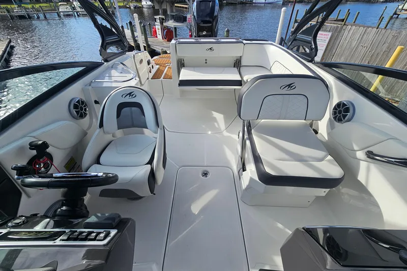 Slide: The Image of 2017 Monterey M-45 boat interior with white seating and steering wheel, docked by the water. - 6