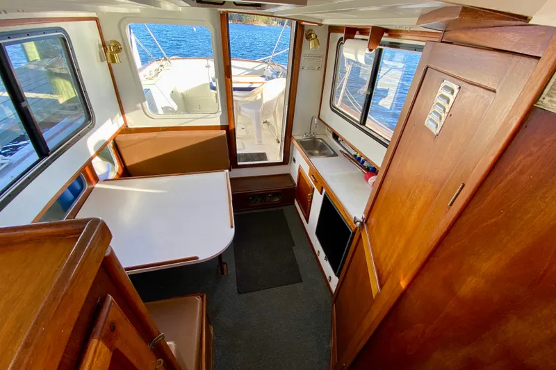 Slide: The Image of Interior of a 1979 Outer Reef 26/31 boat with wood finishes and compact kitchen. - 103