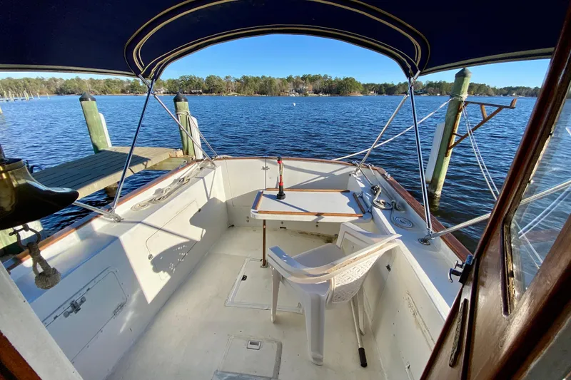 Slide: The Image of 1979 Outer Reef 26/31 boat cockpit with seating, table, and scenic lake view. - 105