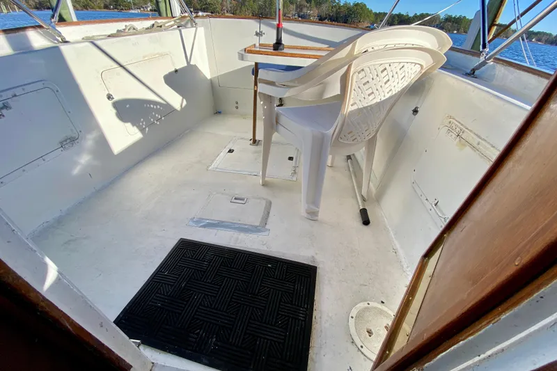 Slide: The Image of 1979 Outer Reef 26/31 boat interior with white plastic chair and table. - 106