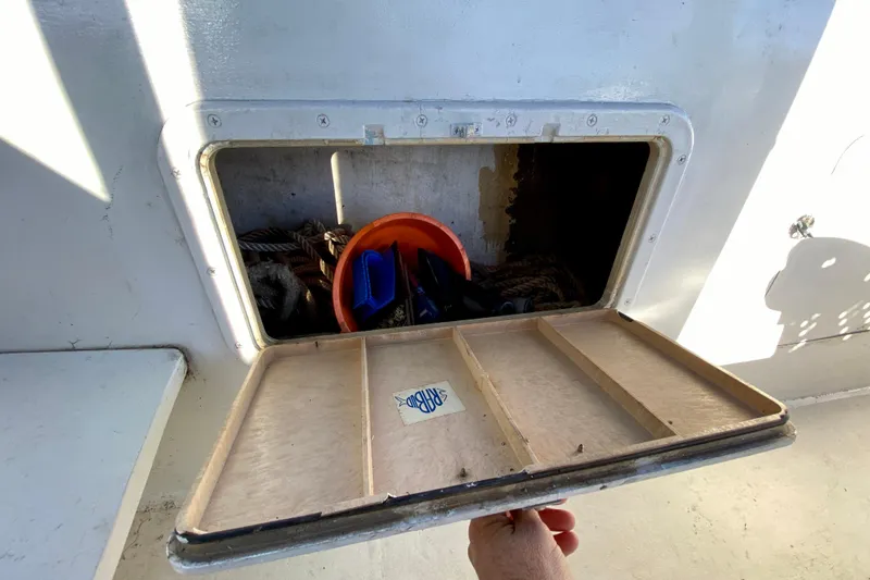 Slide: The Image of Open storage compartment on 1979 Outer Reef 26/31 boat, containing ropes and equipment. - 107