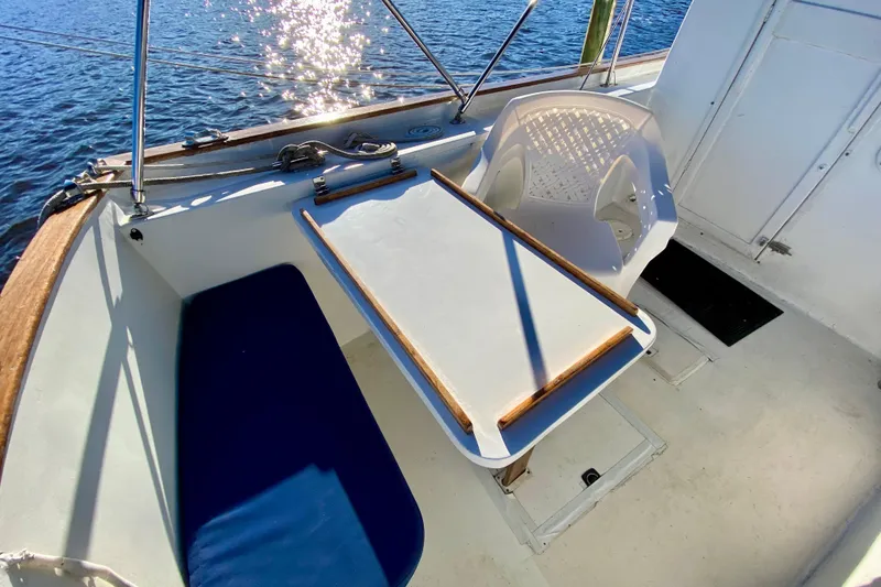Slide: The Image of Cozy seating area on 1979 Outer Reef 26/31 boat with table and chair by the water. - 11