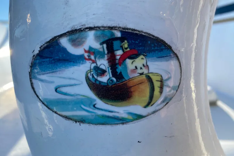 Slide: The Image of Cartoon boat sticker on 1979 Outer Reef 26/31 vessel, featuring a smiling character. - 118