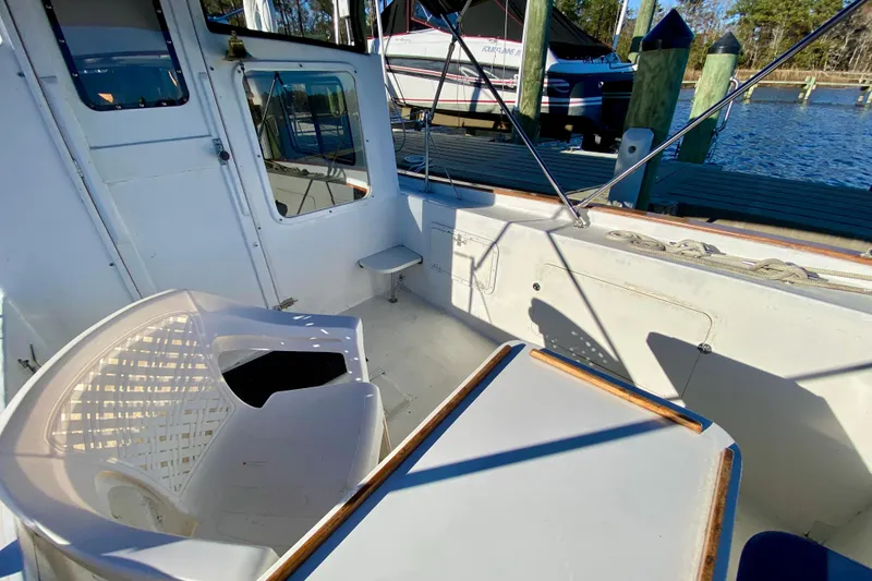 Slide: The Image of 1979 Outer Reef 26/31 boat interior with seating and table, docked by the water. - 12