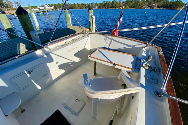 Slide: The Image of 1979 Outer Reef 26/31 boat cockpit with seating, table, and dock view. - 14