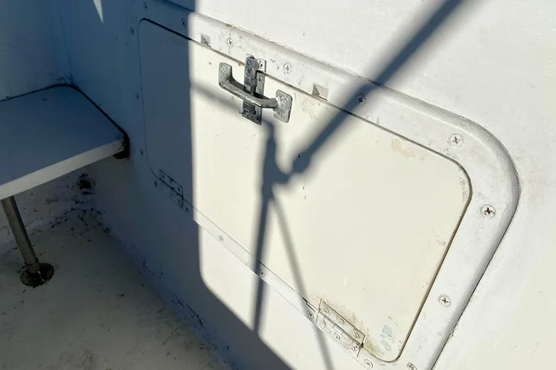 Slide: The Image of White hatch on 1979 Outer Reef 26/31 boat, featuring metal latch and shadow. - 28
