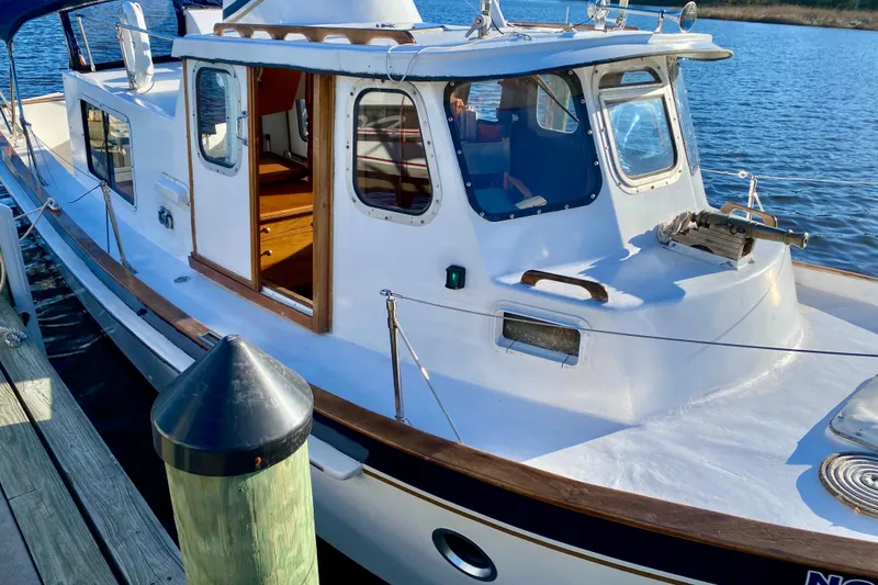 Slide: The Image of Classic 1979 Outer Reef 26/31 boat docked by the water. - 3