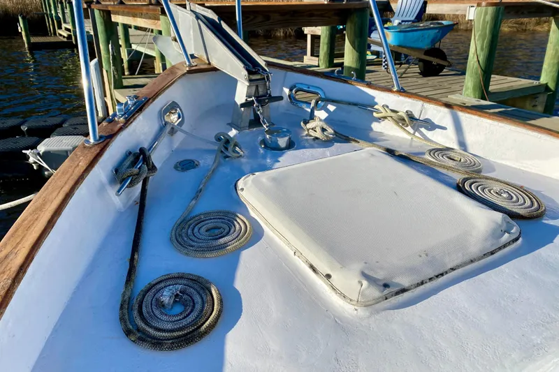 Slide: The Image of Bow of a 1979 Outer Reef 26/31 boat with coiled ropes and deck hatch. - 43