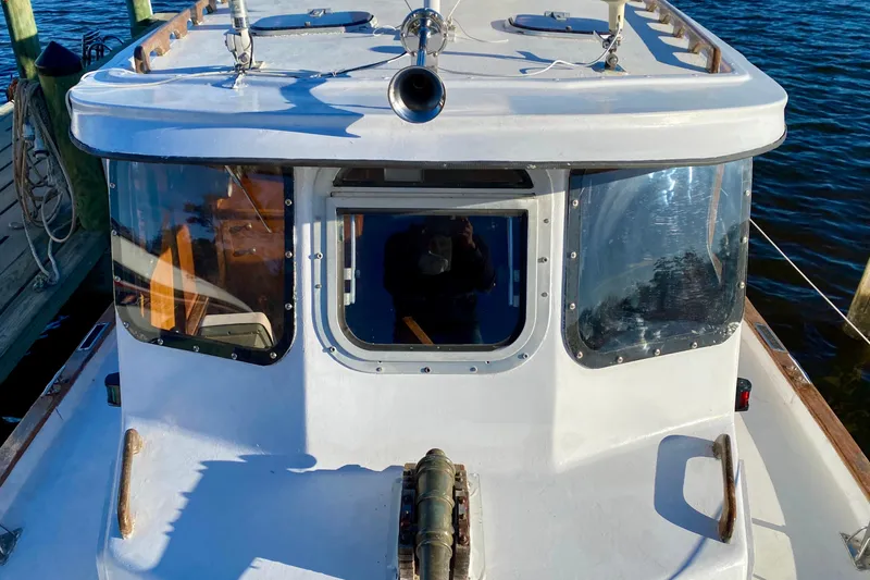 Slide: The Image of 1979 Outer Reef 26/31 boat docked, showcasing cabin windows and deck details. - 47