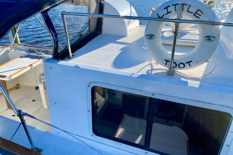 Slide: The Image of 1979 Outer Reef 26/31 boat deck with "Little Toot" lifebuoy, docked by the water. - 5