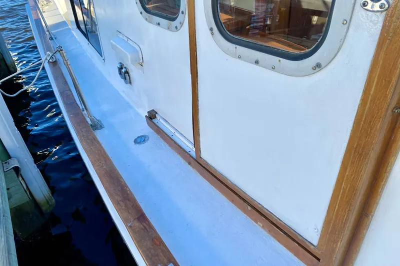 Slide: The Image of 1979 Outer Reef 26/31 boat deck with wooden trim and porthole windows. - 52