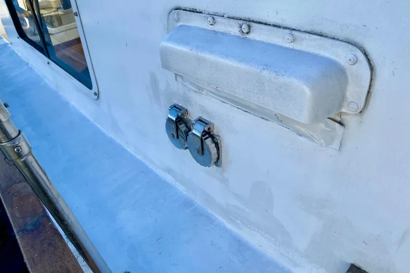 Slide: The Image of Close-up of 1979 Outer Reef 26/31 boat deck with metal fittings and window. - 53