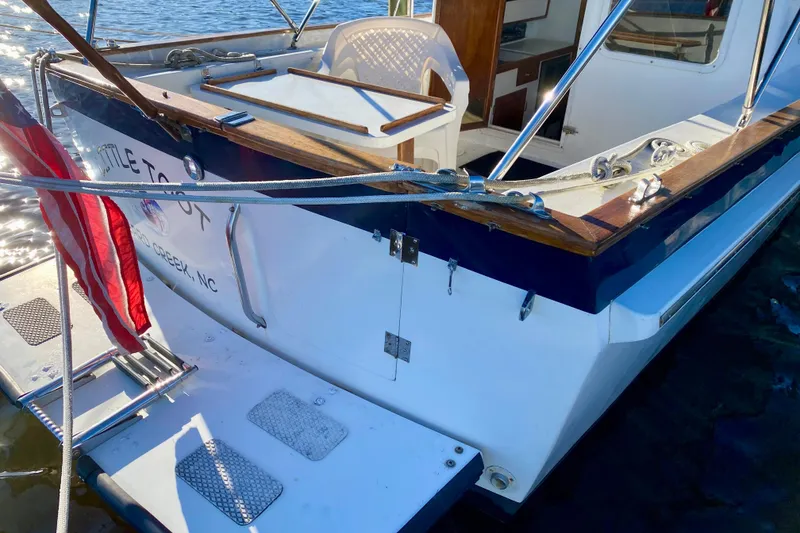 Slide: The Image of 1979 Outer Reef 26/31 boat with American flag, docked on calm water. - 54