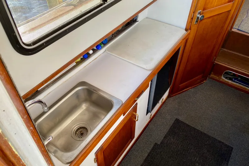 Slide: The Image of 1979 Outer Reef 26/31 boat interior with sink and wooden cabinetry. - 55