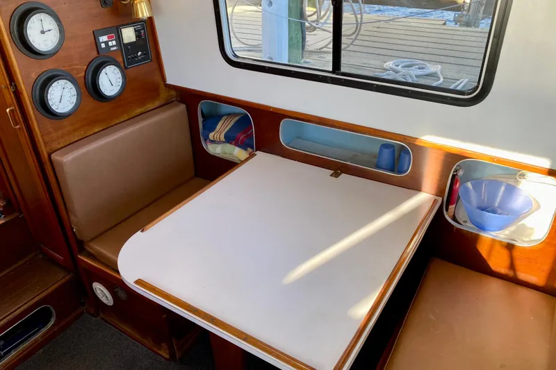 Slide: The Image of 1979 Outer Reef 26/31 boat interior with seating, table, and gauges. - 56