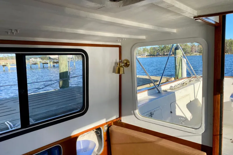 Slide: The Image of Interior view of 1979 Outer Reef 26/31 boat with windows overlooking a serene waterfront. - 58