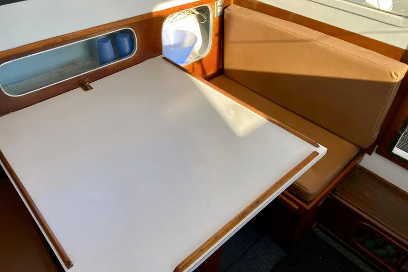 Slide: The Image of 1979 Outer Reef 26/31 interior with table, cushioned seating, and storage shelf. - 59