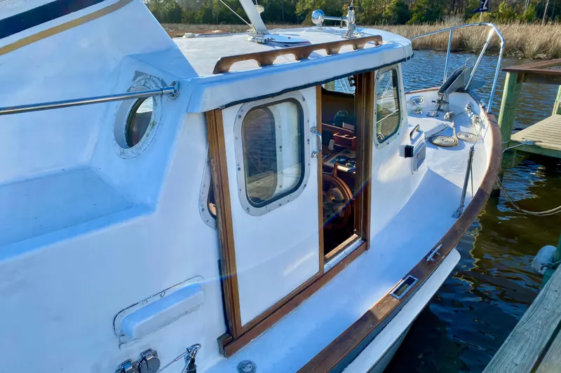 Slide: The Image of 1979 Outer Reef 26/31 boat docked, showcasing wooden trim and classic design. - 6