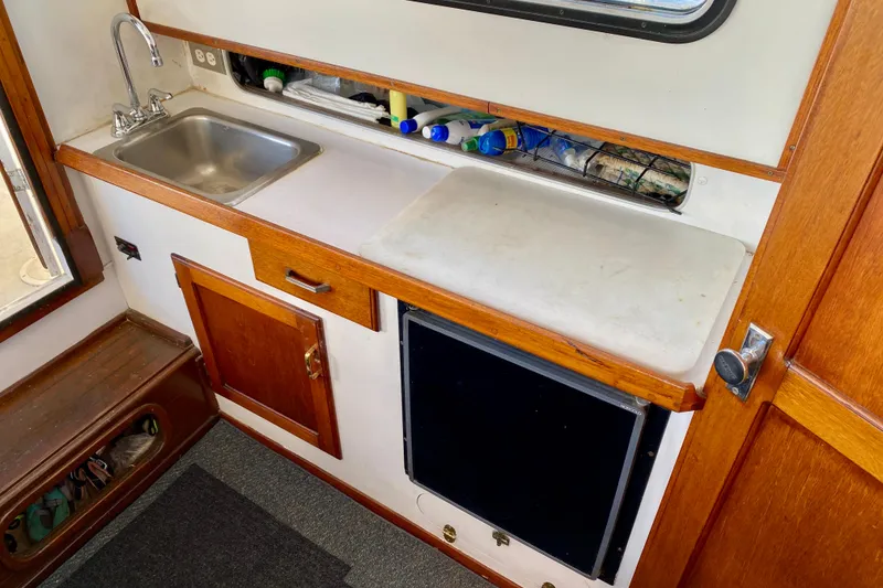 Slide: The Image of 1979 Outer Reef 26/31 boat interior with sink, countertop, and storage. - 60