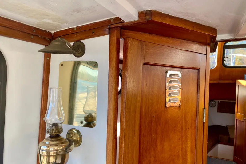 Slide: The Image of Interior of a 1979 Outer Reef 26/31 boat with wooden paneling and vintage lamp. - 62
