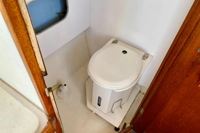 Slide: The Image of Compact marine toilet in a 1979 Outer Reef 26/31 boat bathroom. - 65