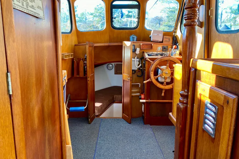 Slide: The Image of Interior of a 1979 Outer Reef 26/31 boat with wooden helm and cozy cabin. - 69