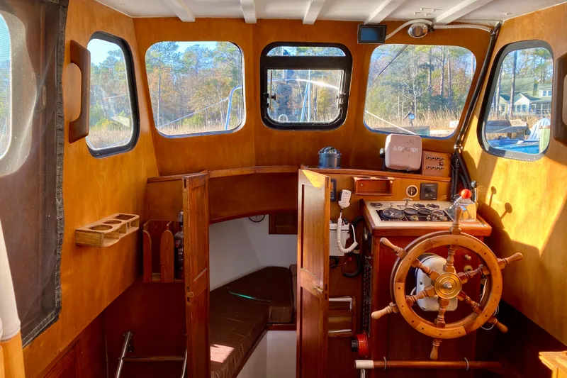 Slide: The Image of Interior of a 1979 Outer Reef 26/31 boat with wooden helm and cozy cabin. - 71