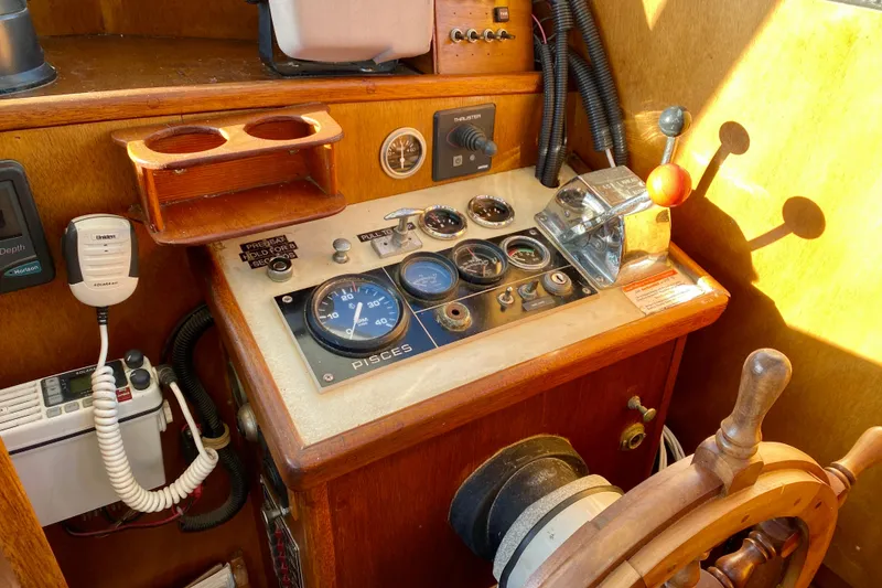 Slide: The Image of 1979 Outer Reef 26/31 boat cockpit with vintage controls and wooden steering wheel. - 77